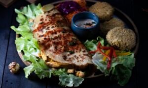 Fresh shawarma wrap with garlic sauce, pickles, and fries, the workhorse Levantine street food of Ajman