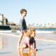 Two children playing on a sandy beach at the water's edge