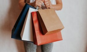 Person holding colourful shopping bags after a sale