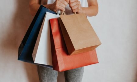 Person holding colourful shopping bags after a sale