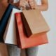 Person holding colourful shopping bags after a sale