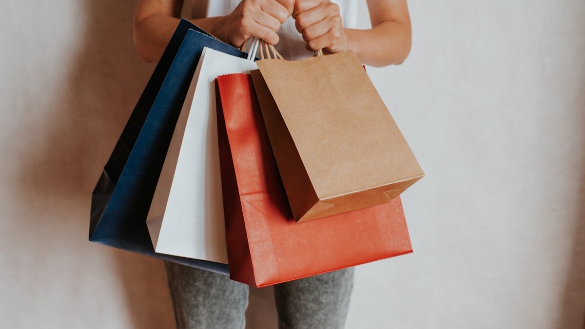 Person holding colourful shopping bags after a sale