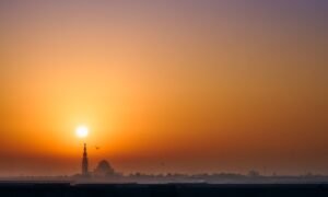Ajman skyline at sunset with residential apartment towers along the coast
