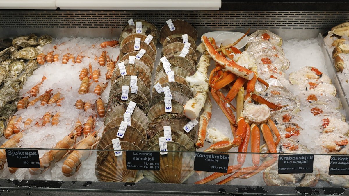 Whole fresh fish displayed on crushed ice at a working seafood counter