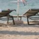 Sun loungers and an umbrella on a resort beach at golden hour